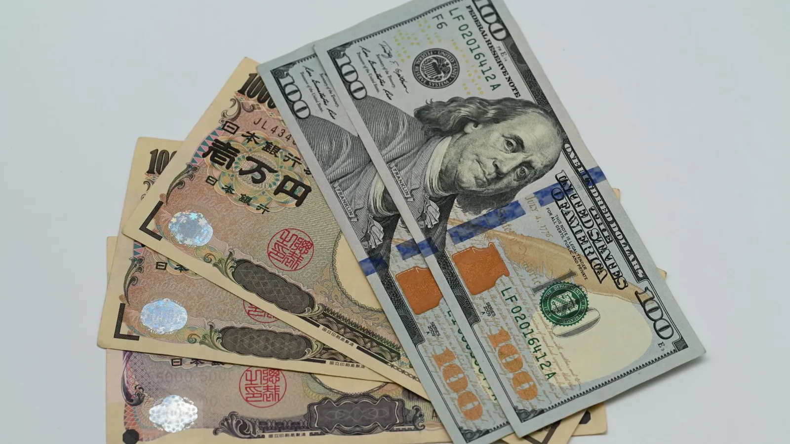 Close-up image of US dollars and Japanese yen notes, representing currency exchange concept.